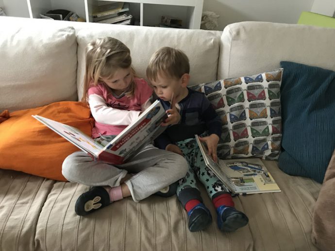 Geschwister beschäftigen sich gemeinsam Buchlesen